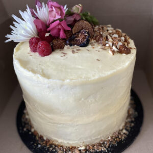 Carrot cake topped with roasted nuts and fresh fruit